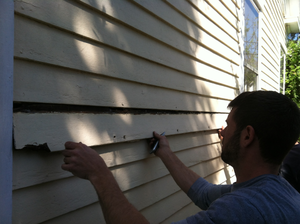 Taking a piece of wood siding off my 1835 home to expose the foam insulation in the walls