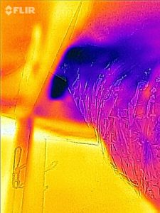 Infrared image of a duct going from a knee wall attic into another attic and leaking heat like crazy