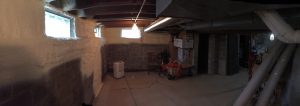 Panoramic view of partially spray foamed basement walls