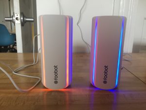 Two Foobot Indoor Air Quality monitors side by side. I blew into the one on the left which stirs up dust and made it read bad or orange.
